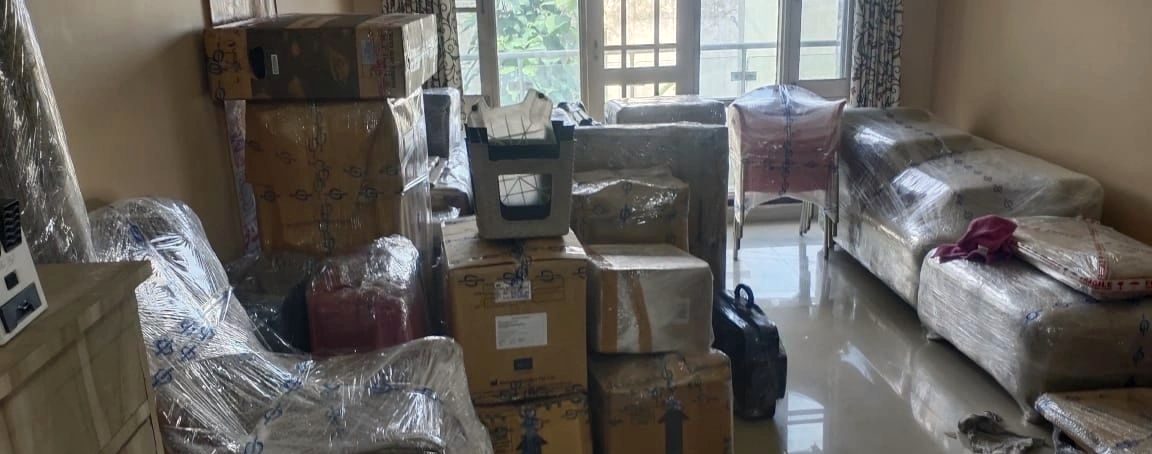 A living room fully packed by the Senani crew — sofas wrapped, cartons sealed and labeled
