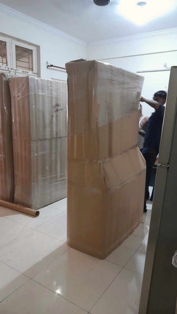 A wardrobe wrapped in corrugated sheet and stretch film, ready to move