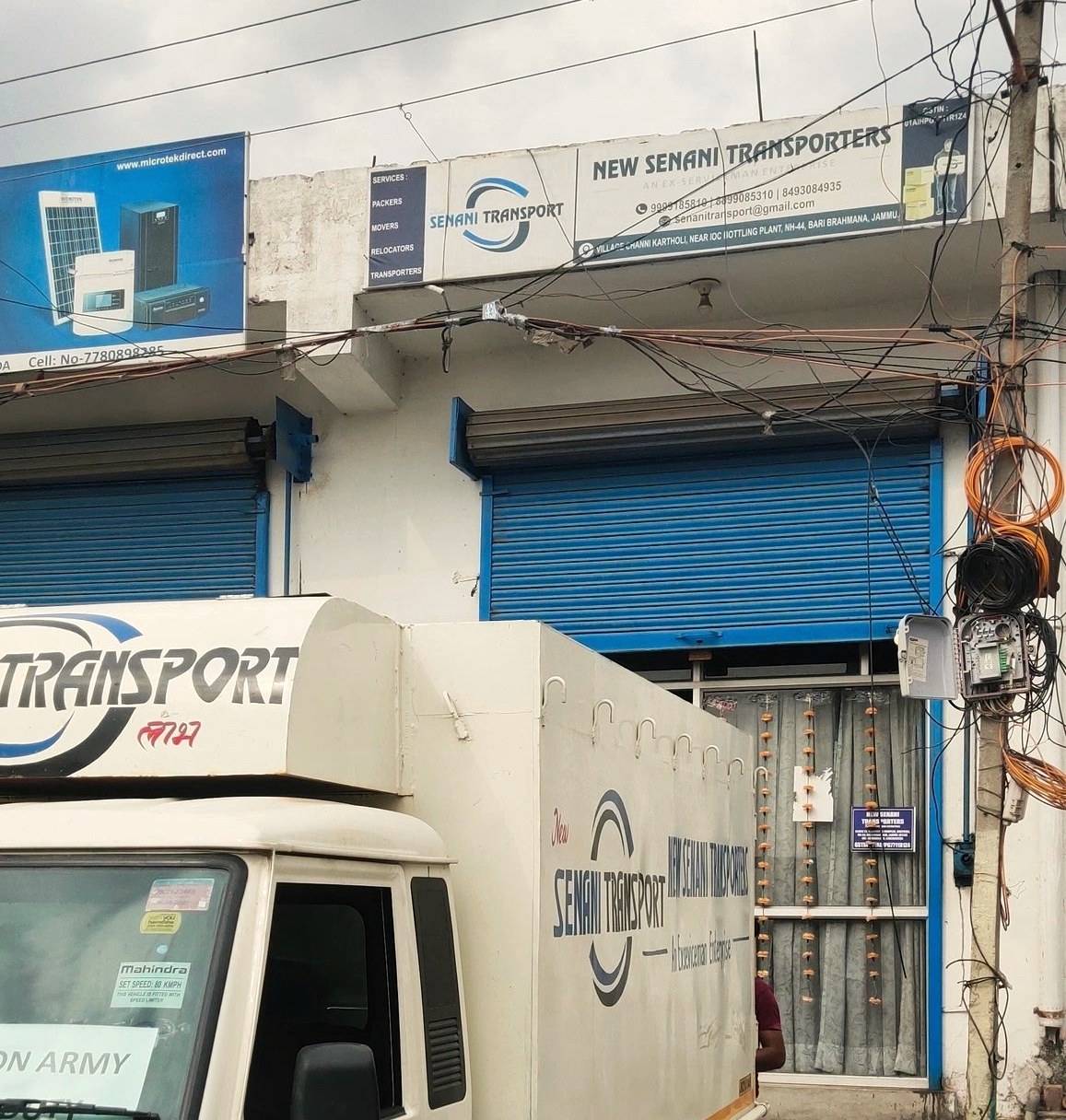 New Senani Transporters depot on NH-44, Bari Brahmana — signboard reading 'An Ex-Serviceman Enterprise' above a branded pickup truck carrying an 'ON ARMY DUTY' board